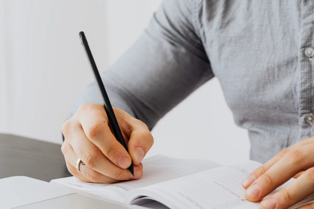 Person reviewing a website testing checklist beside a laptop and smartphone